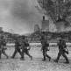 Немецкие пулеметчики идут вдоль сгоревших домов по улице в Ясеновке Фото