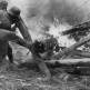 Немецкие солдаты разбирают препятствие из горящих бревен на советско-германском фронте Фото